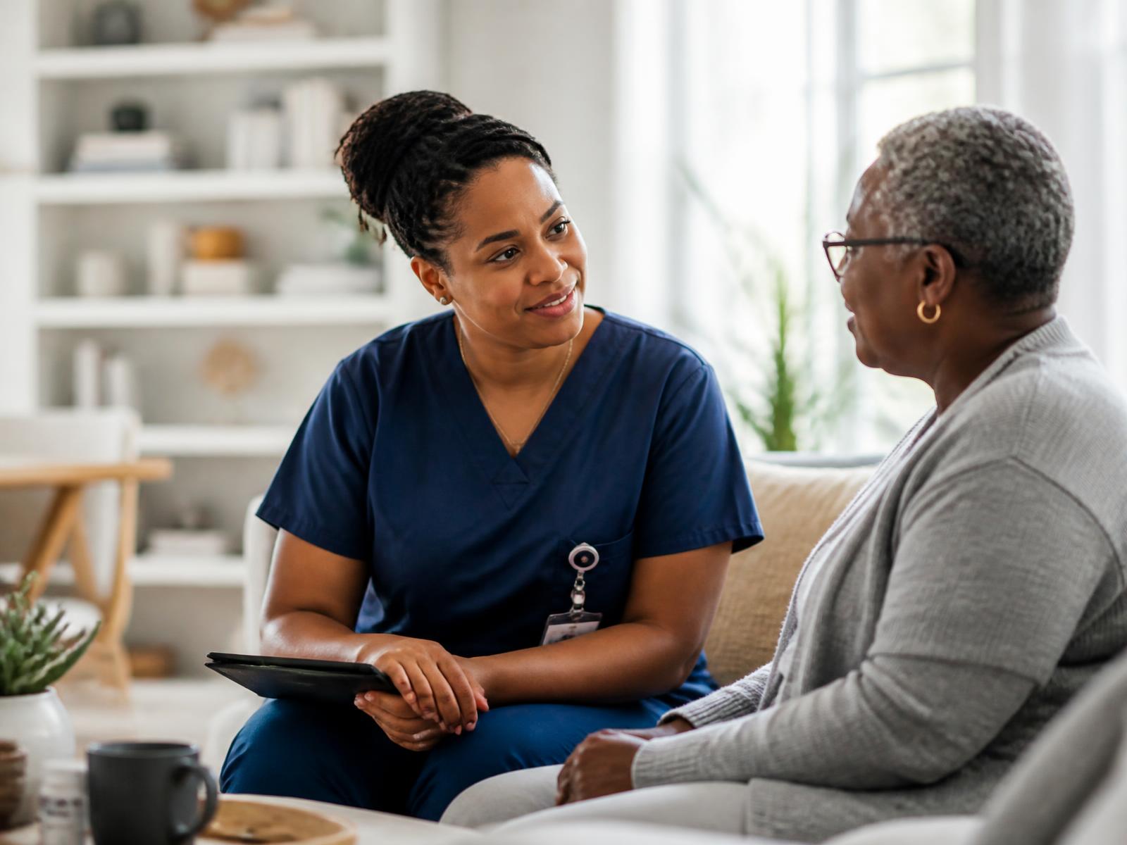 An Oslume Health care team member meeting with an older adult in her home